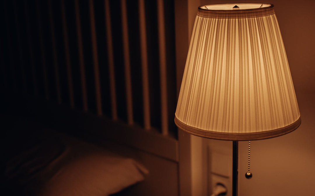 Lampe de chevet allumée dans une chambre le soir